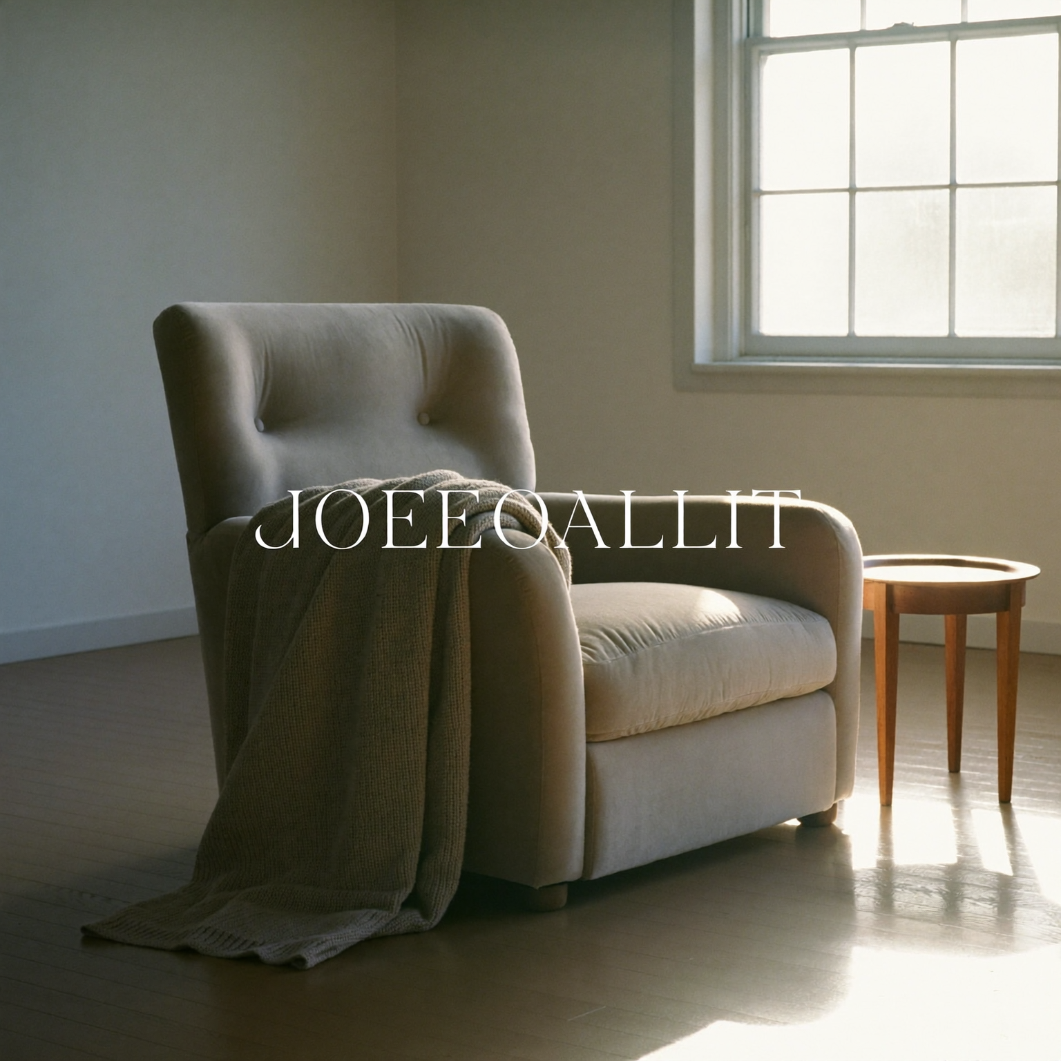 A reclining chair beside a sunlit window with a folded blanket over one arm.
